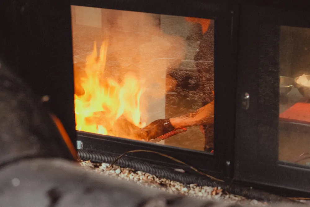 Flammes derrière la vitre d'un poêle moderne